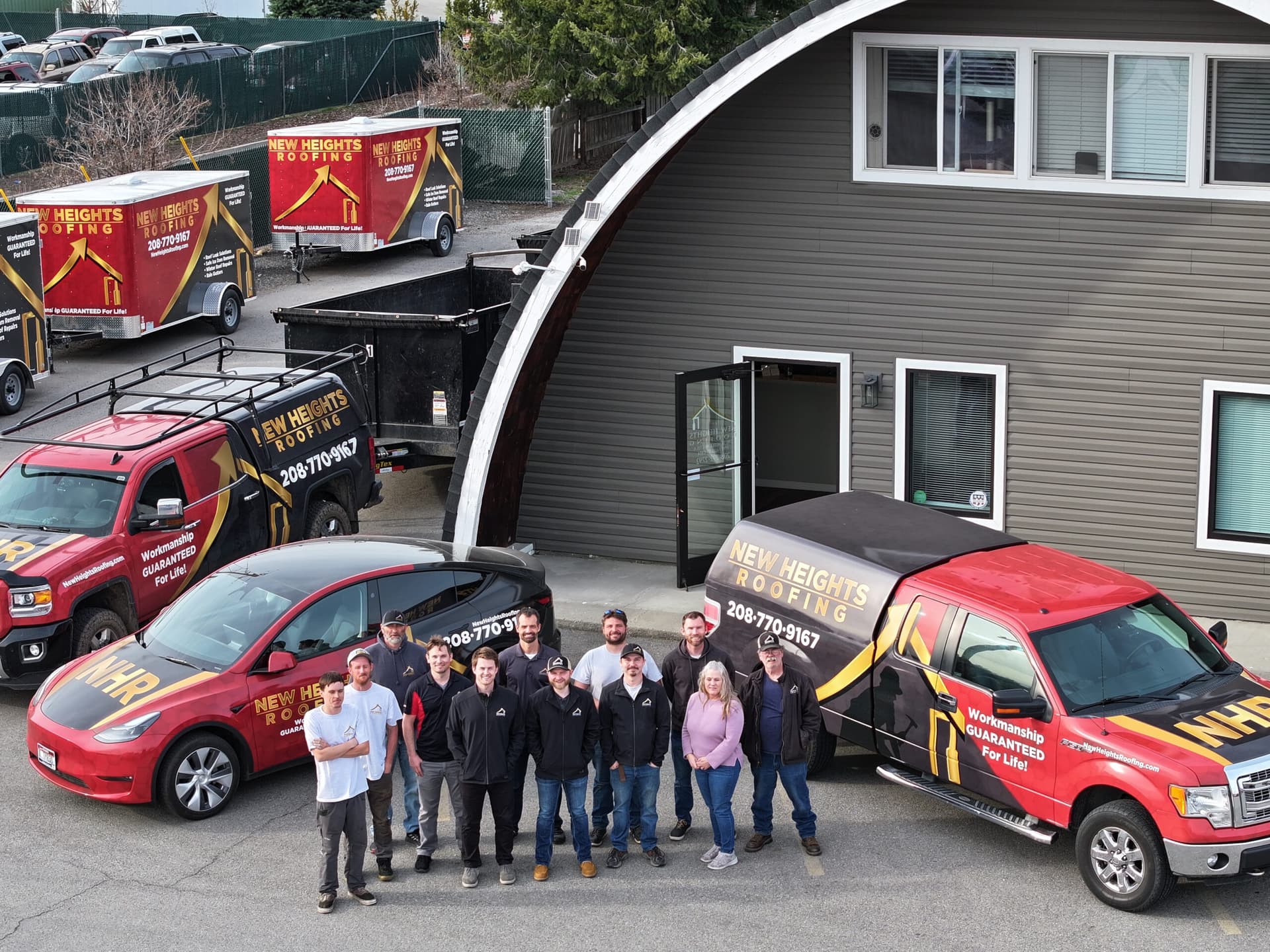 Tyson Faulkner and the New Heights Roofing team standing with their trucks in Post Falls, Idaho
